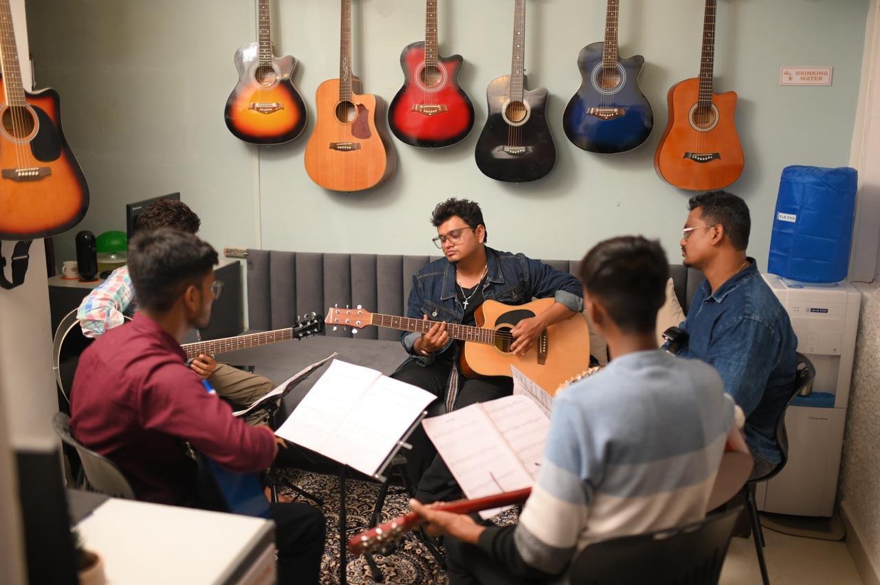 Students and teacher playing guitar together